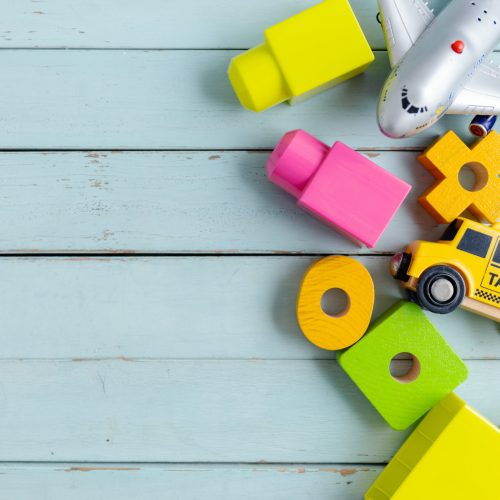 Children play background with toys on blue background. Top View.